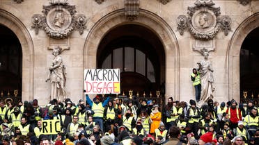 Protesters wearing yellow vests gather in front of the Opera House as part of the "yellow vests" movement in Paris, France, December 15, 2018. Sign reads, "Macron Get Out". REUTERS/Christian Hartmann
