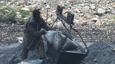 A worker at Darra Adam Khel coalmine unloading coal trolley. (Supplied)