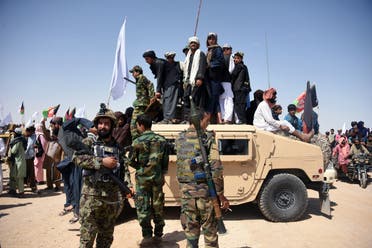 Afghan Taliban militants and residents stand on an armoured Humvee vehicle of the Afghan National Army (ANA) in Maiwand district of Kandahar province on June 17, 2018. (AFP)