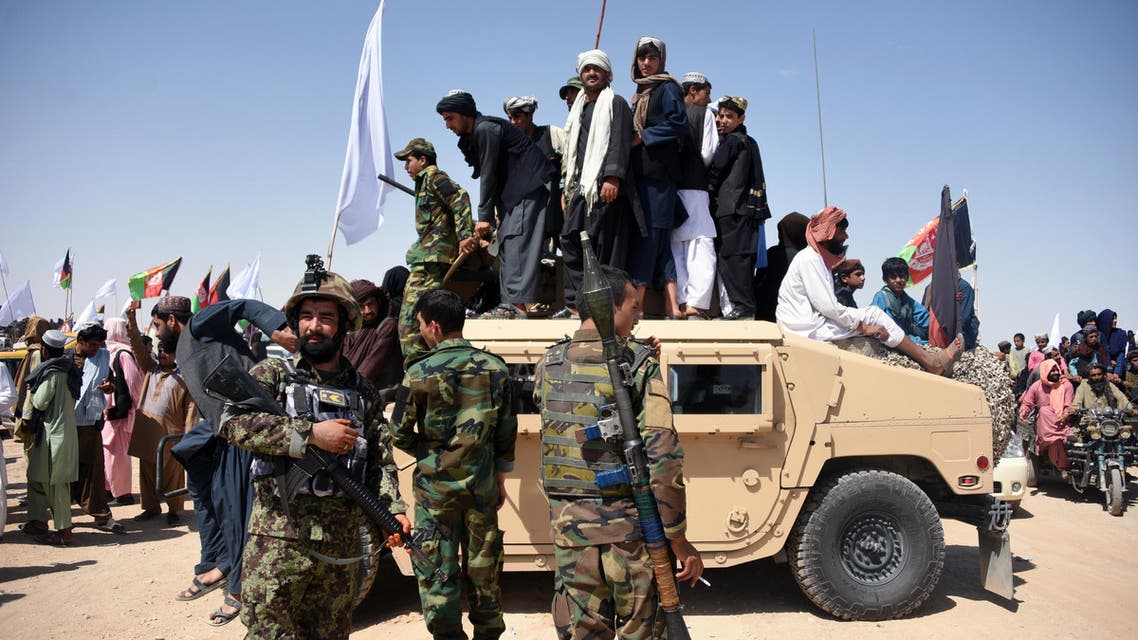 Afghan Taliban militants and residents stand on an armoured Humvee vehicle of the Afghan National Army (ANA) in Maiwand district of Kandahar province on June 17, 2018. (AFP)