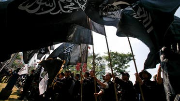 Indonesian Muslim men hold up flags during a protest against China’s crackdown on the Muslim Uighurs, outside Chinese Embassy in Jakarta, on July 14, 2009. (File photo: AP)