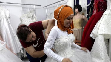 Nadia Mohammad Salem tries on a wedding dress in Cairo. (Reuters)