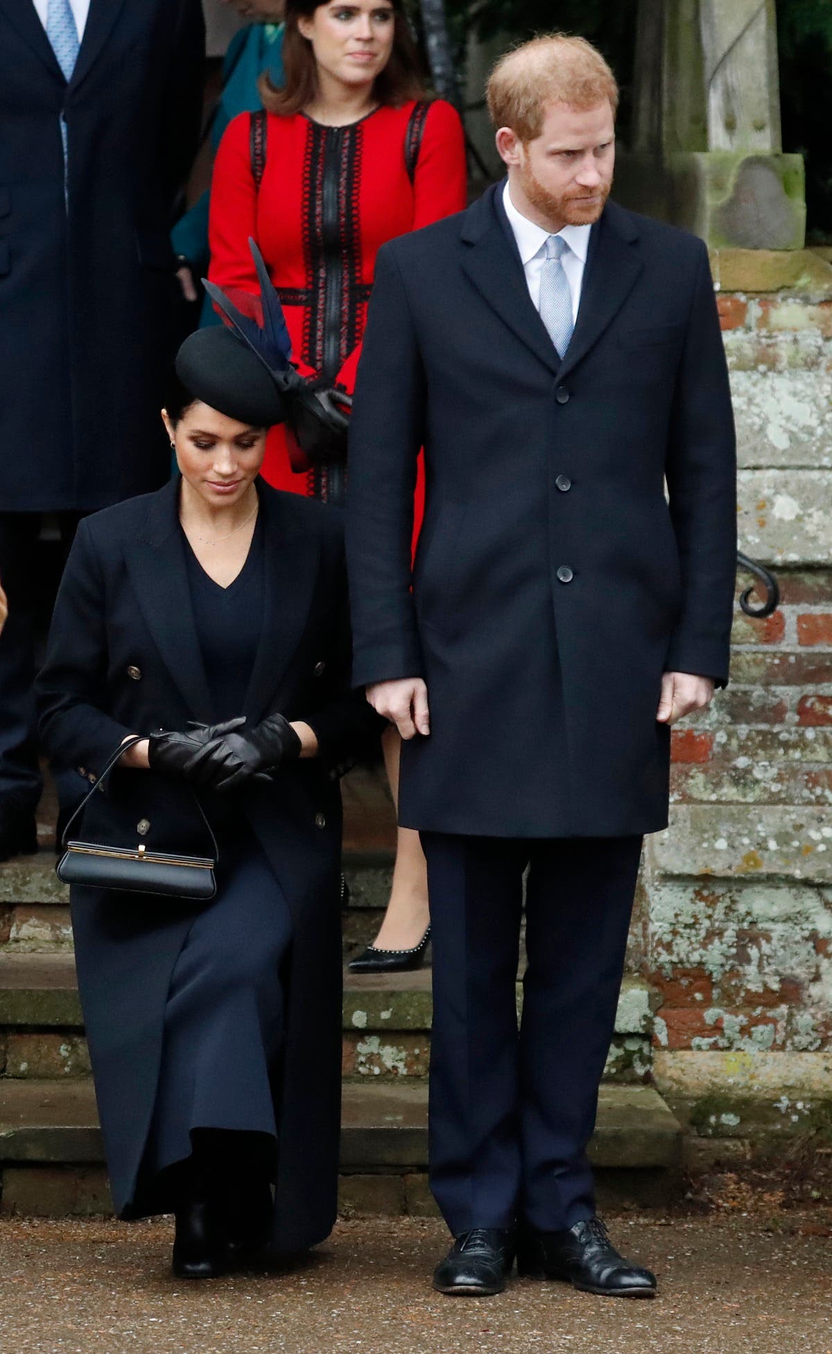 Britain's Prince Harry, stands with Meghan, Duchess of Sussex as she does a curtsy to Britain's Queen Elizabeth II as she leaves in a car after attending the Christmas day service. (AP)