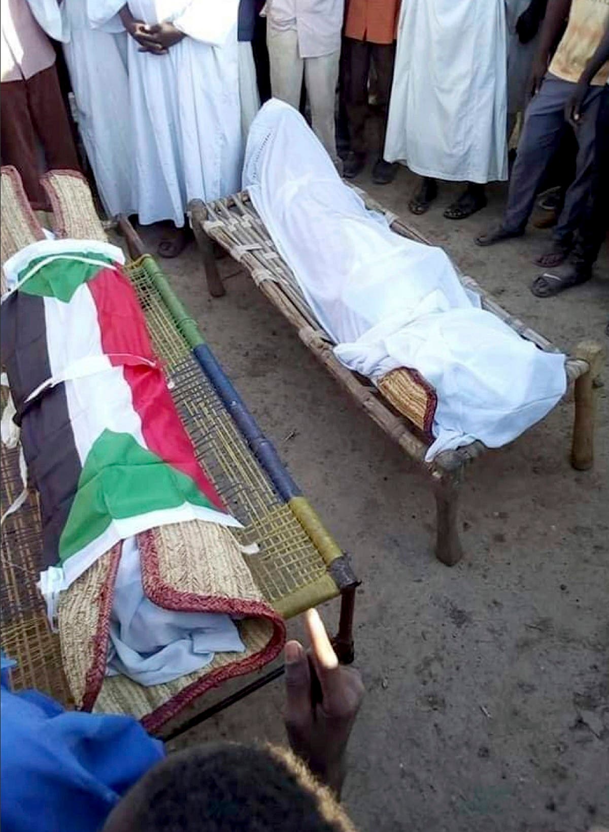 In this Friday Dec. 21, 2018 handout photo provided by a Sudanese activist, people pray in front of the bodies of 14-year old Mohammed Ismail and 10-year old Shawky Sadeq who were both killed during an anti-government protest. (AP)