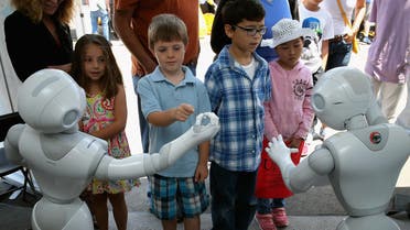 Children interact with Aldebaran’s Pepper robot in California on June 6, 2015. (AFP)