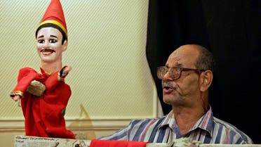 Egyptian puppeteer Mustafa Othman performs with his Aragoz puppet at the Egyptian National Theater in Cairo on 16 August 2004. (AFP)