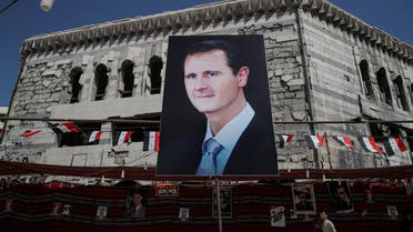 A man walks past a banner showing Syrian President Bashar al-Assad in Douma, outside Damascus on September 17, 2018. (Reuters)