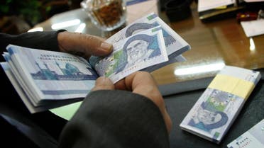 An Iranian bank teller counts new 20,000 rial notes at Iran's Central Bank in Tehran March 15, 2004. Iran began to release the new 20,000 rial note equivalent to $2.38 shortly before the Iranian new year which begins March 21. REUTERS/Morteza Nikoubazl CJF/AA