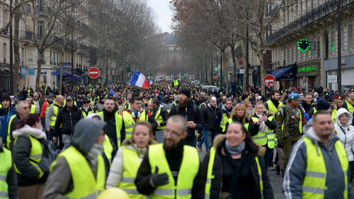 Yellow vest protestors hoist an effigy with a French national flag in front of The Arc de Triomphe on The Champs-Elysees in Paris on January 5, 2019, during a rally by yellow vest "Gilets Jaunes" anti-government protestors. Over the past six weeks, "yellow vest" demonstrators -- so-called after the high-visibility jackets they wear -- have repeatedly clashed with police in Paris and other big cities, plunging Macron's presidency into crisis. The "yellow vest" movement began in rural France over fuel taxes and quickly ballooned into a wider revolt against the 41-year-old president's pro-business policies and perceived arrogance by low-paid workers and pensioners.