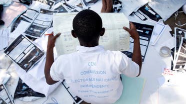 Man examines voting materials at CENI tallying centre in Kinshasa. (Reuters)