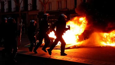 Riot policemen run near a fire during a demonstration by the "yellow vests" movement at Boulevard Saint Germain in Paris, France. (Reuters)