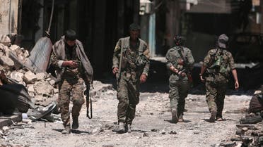 FILE PHOTO: Syria Democratic Forces (SDF) fighters walk on the rubble of damaged shops and buildings in the city of Manbij, in Aleppo Governorate, Syria, August 10, 2016. REUTERS/Rodi Said/File Photo