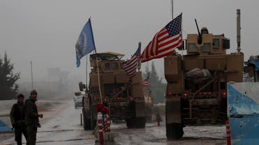A line of US military vehicles drive through a checkpoint of the Internal Security Forces in Manbij. (File photo: AFP)