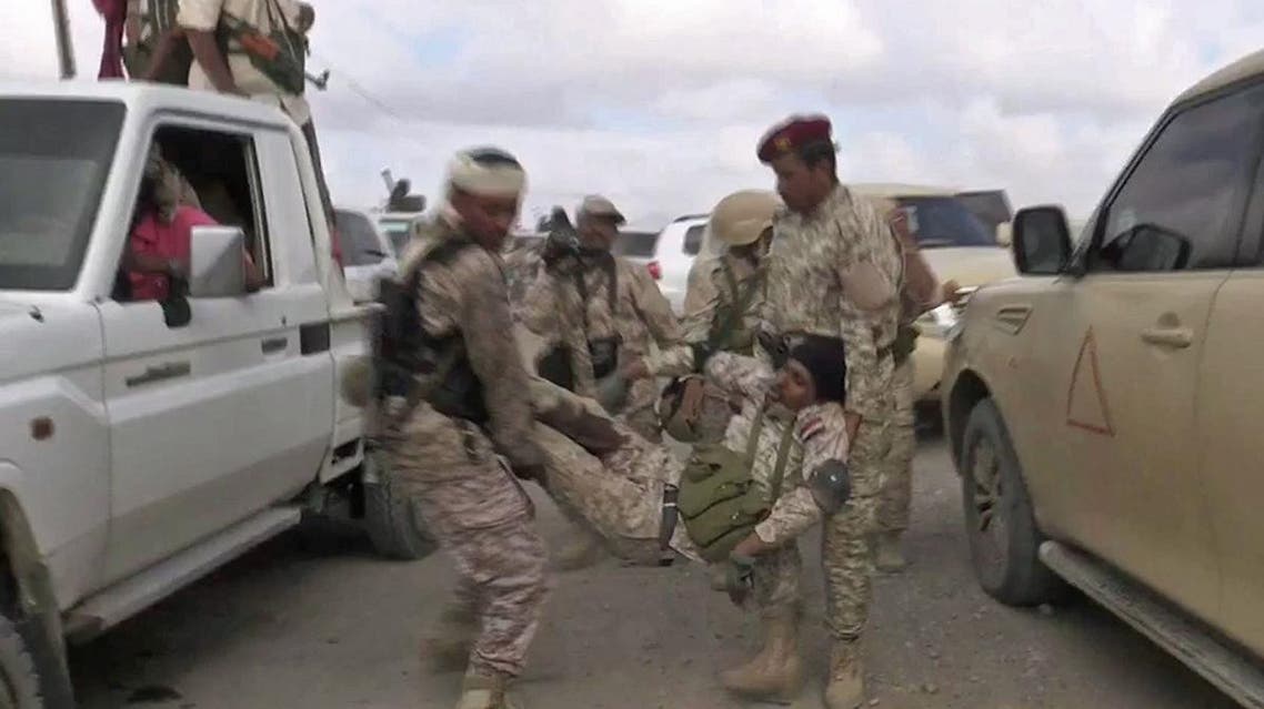 An image grab taken from a video obtained by AFPTV shows a wounded Yemeni soldier being carried by comrades after a drone exploded above Yemen's al-Anad airbase. (AFP)
