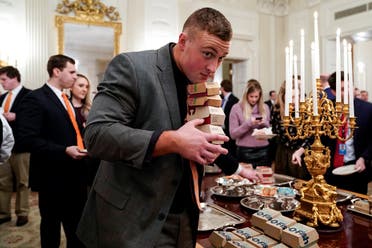 A Clemson player carries fast food hamburgers provided due to the partial government shutdown as the 2018 College Football Playoff National Champion Clemson Tigers are welcomed in the State Dining Room of the White House in Washington. (Reuters)