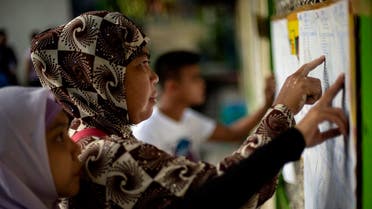 Muslim women look for their names at a voting precinct in Maguindanao, on the southern island of Mindanao. (Reuters)