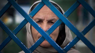 Picture taken March 28, 2013 shows Afghan female prisoner Fauzia steering out of the prison bars at Badam Bagh, Afghanistan's central women's prison, in Kabul, Afghanistan.(AP)