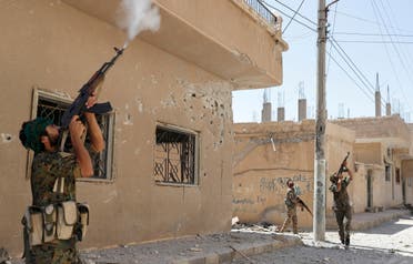 Kurdish fighters from the People's Protection Units (YPG) fire rifles at a drone operated by ISIS militants in Raqqa, Syria, June 16, 2017. (Reuters)