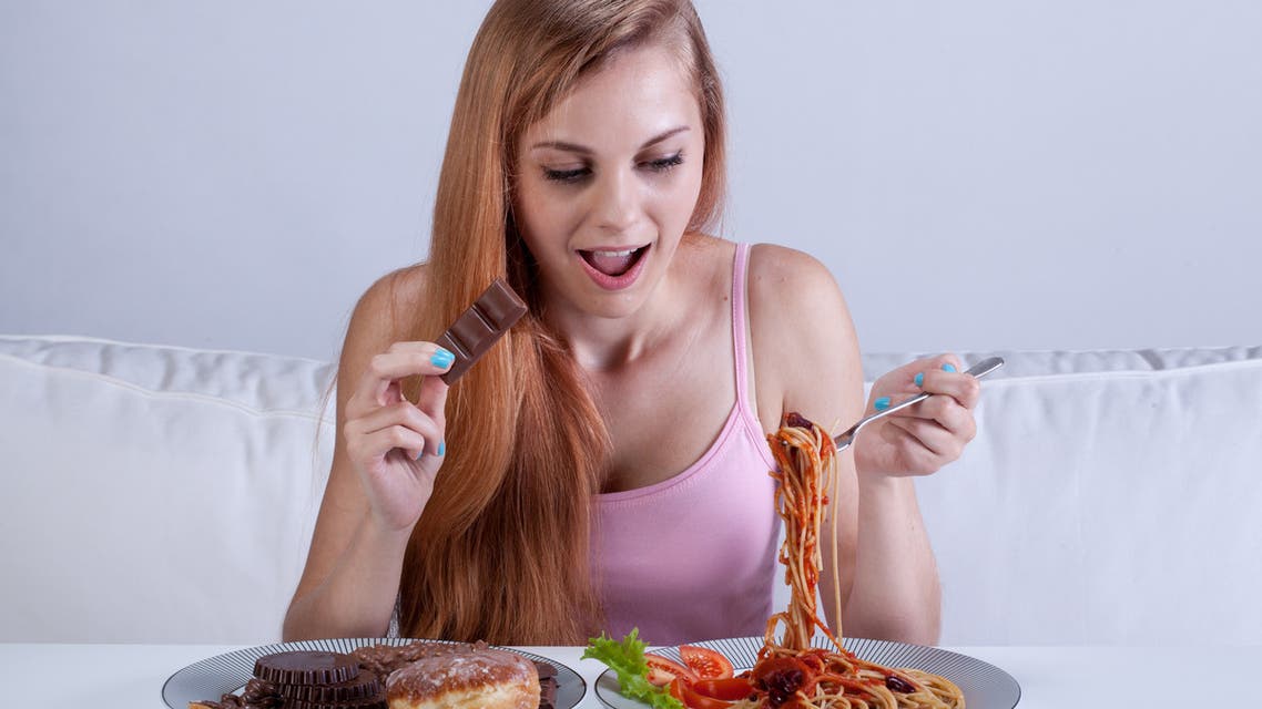 Girl suffering from bulimia eats dinner - Stock image