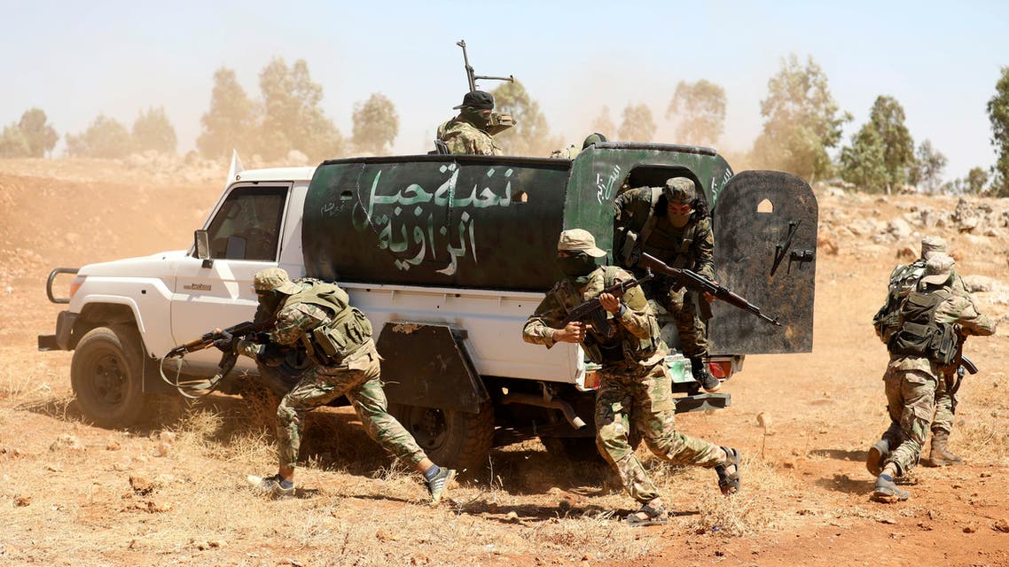Syrian fighters attend a mock battle in anticipation of an attack by the regime on Idlib province and the surrounding countryside, during a graduation of new Hayat Tahrir al-Sham (HTS) members at a camp in the countryside of the northern Idlib province on August 14, 2018.