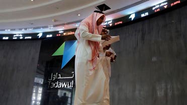 Saudi men walk at the Tadawul Saudi Stock Exchange in Riyadh. (Reuters)