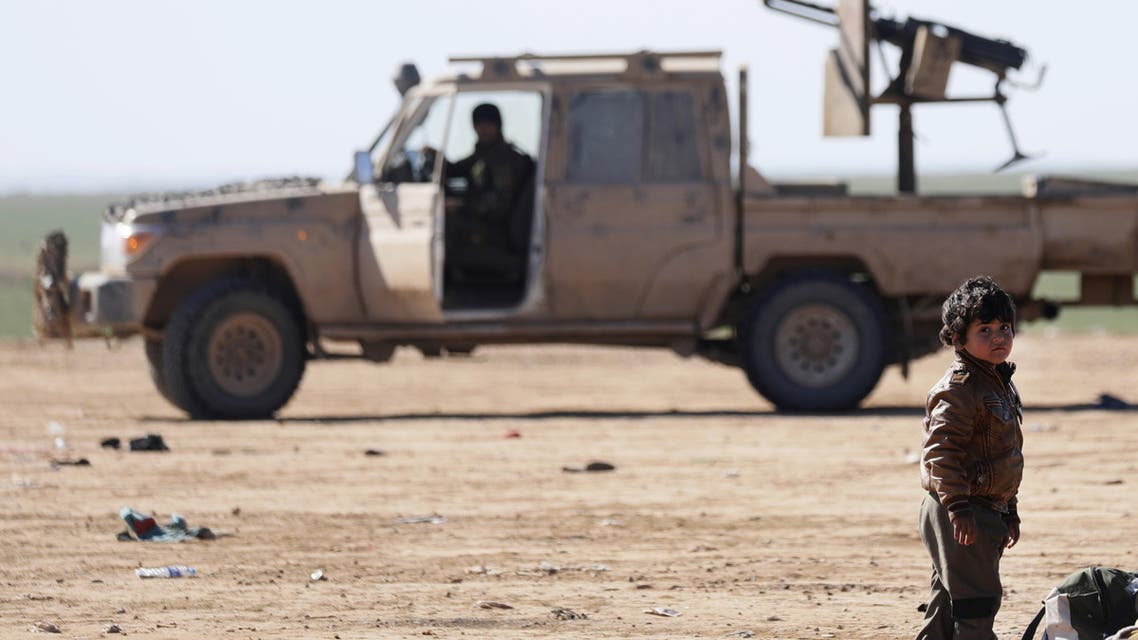 A youth who fled fighting between Syrian Democratic Forces (SDF) and Islamic State (IS) jihadists in the frontline Syrian village of Baghuz, awaits to be screened and registered by the SDF in the countryside of the eastern Syrian Deir Ezzor province on February 3, 2019.