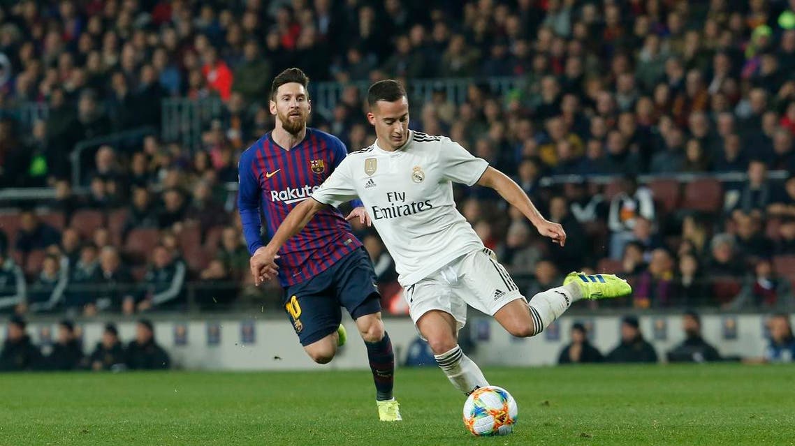 Barcelona’s Messi (L) vies for the ball with Real Madrid’s Vazquez (AFP)