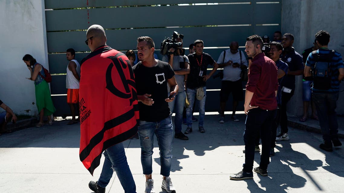 Friends, fans and journalists stand at the entrance of the Flamengo soccer training center as they wait for information after a fire in the facilities of the soccer club in Rio de Janeiro, Brazil, Friday, Feb. 8, 2019 (AP)