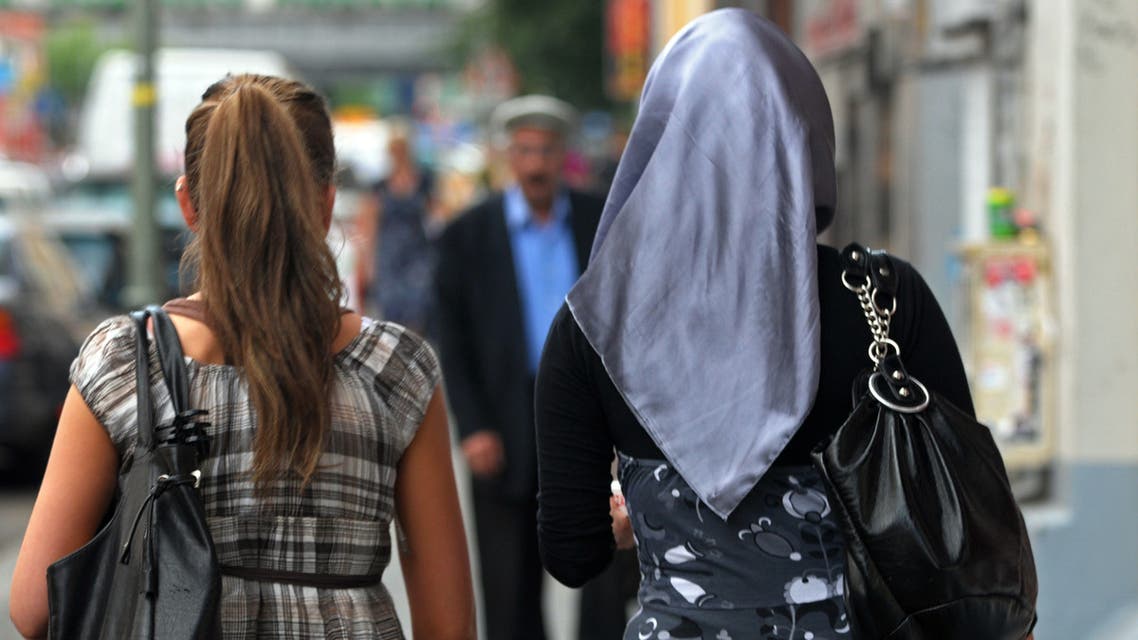 Two women, one being veiled (R), walk along a street in the Berlin district of Kreuzberg - Neukoelln on July 16, 2009. Around 120,000 Turks live currently in Berlin, which has a total population of 3.4 millions. AFP PHOTO KAVEH ROSTAMKHANI