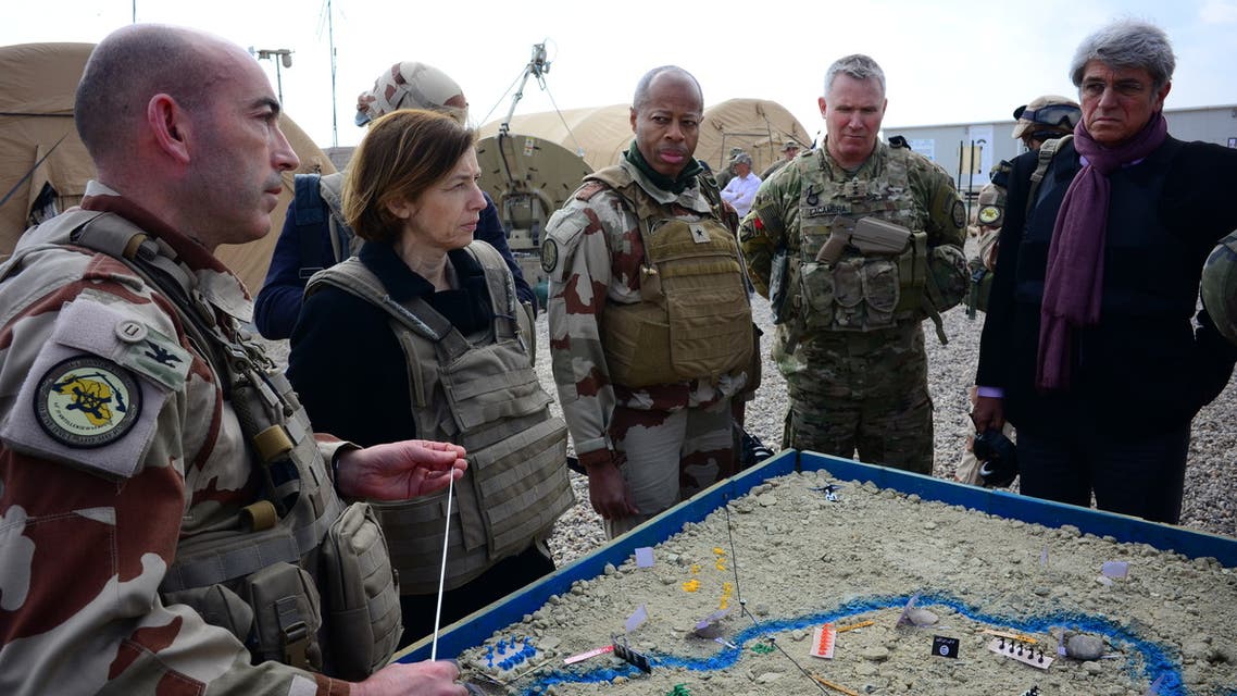 (L to R) French Major of the Wagram Task Force Francois-Regis Legrier explains military positions on a sand map to French Defence Minister Florence Parly, French General Jean-Marc Vigilant, US Army General Paul La-camera, and French ambassador to Iraq Bruno Aubert, at a French artillery forward operating base (FOB) near al-Qaim in Iraq's western Anbar province opposite Syria's Deir Ezzor region, a few kilometres away from the last scrap of territory held by IS, on February 9, 2019.