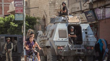 Egyptian policemen stand guarding a street in the North Sinai provincial capital of El-Arish, on July 26, 2018. (AFP)