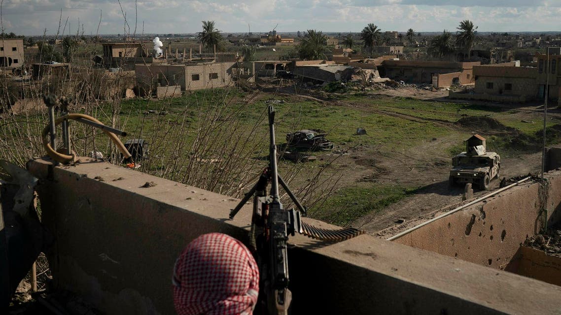 A Syrian Democratic Force fighter stands atop a building near the last land still held by ISIS in Baghouz, Syria on Feb. 18, 2019. (AP)