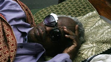 Osman Mirghani, chief editor of the Al-Tayar daily, lies on his bed after he was severely beaten by armed men who raided the offices of the Sudanese newspaper on July 24, 2014. (AFP)