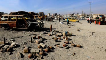 Shells and undetonated mines strewn near a burnt-out vehicle on a street in Syria’s Raqa that were left by ISIS. (File photo: AFP)