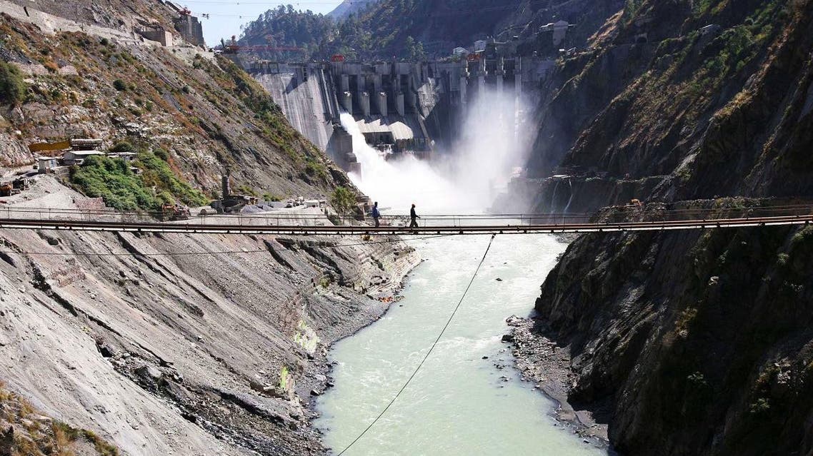 Laborers walk on a bridge near the newly inaugurated 450-megawatt hydropower project at Chanderkote. (Reuters)