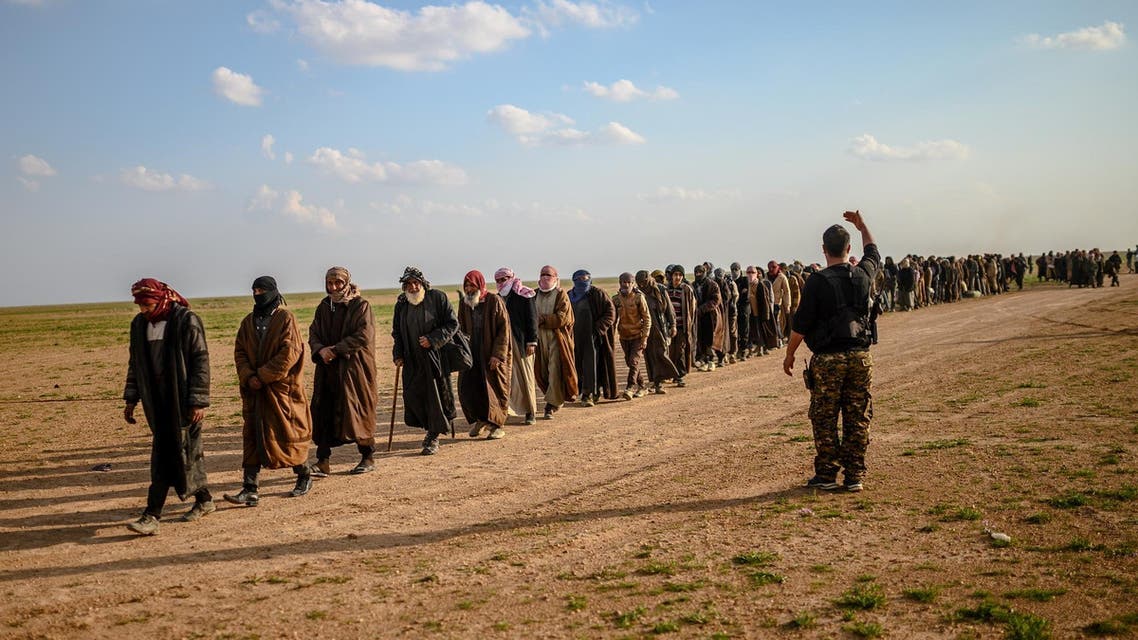 Men suspected of being ISIS fighters wait to be searched by members of the SDF after leaving the group’s last holdout of Baghouz in Syria, on February 22, 2019. (AFP)