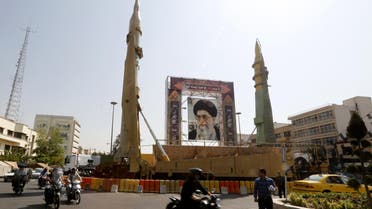 Iranians walk past Sejjil (L) and Qadr-H medium range ballistic missiles displayed next to a portrait of Iranian Supreme Leader Ayatollah Ali Khamenei on the occasion of the annual defence week which marks the anniversary of the 1980s Iran-Iraq war, on September 25, 2017, on Baharestan square in Tehran. 