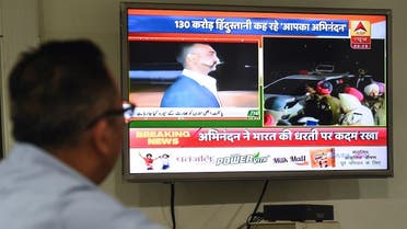 An Indian man watches live news channels broadcasting images of Indian Air Force Wing Commander Abhinandan Varthaman returning to India from the India-Pakistan Wagah border in New Delhi on March 1, 2019. (AFP)