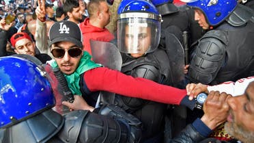 An Algerian demonstrator has his arm pulled between members of the security forces during a protest rally against ailing President Abdelaziz Bouteflika’s bid for a fifth term in power, in the capital Algiers on March 1, 2019. (AFP)