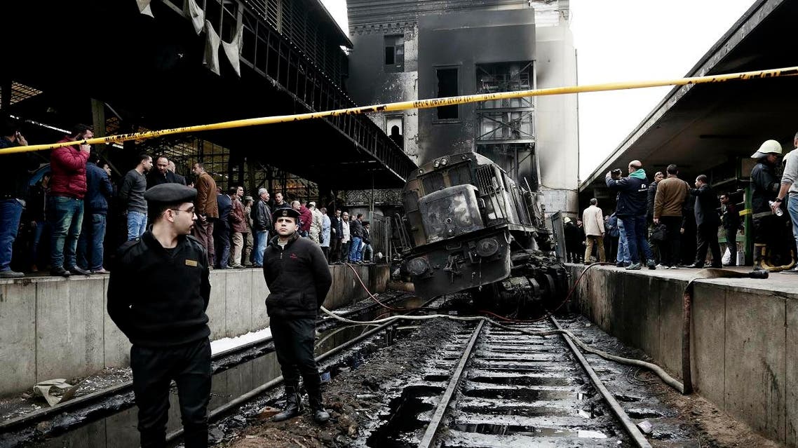 Policemen stand guard in front of a damaged train inside Ramsis train station in Cairo, Egypt, Wednesday, Feb. 27, 2019. (AP)