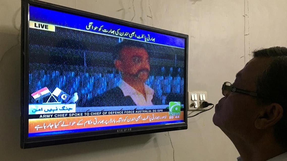 A man looks at a TV screen airing live transmission of released Indian pilot Wing Commander Abhinandan, at Wagah border, in Karachi, Pakistan on March 1, 2019. (Reuters)
