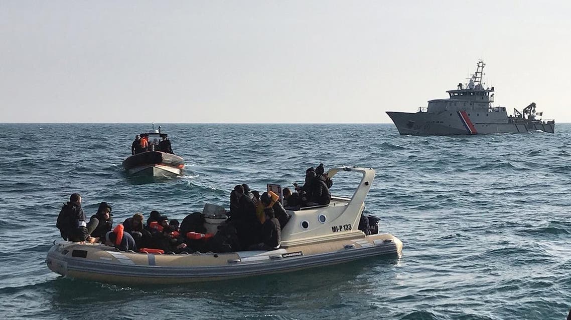 British rescuers (front) helping some 20 migrants on a semi-rigid boat trying make their way from France across the English Channel. (AFP)