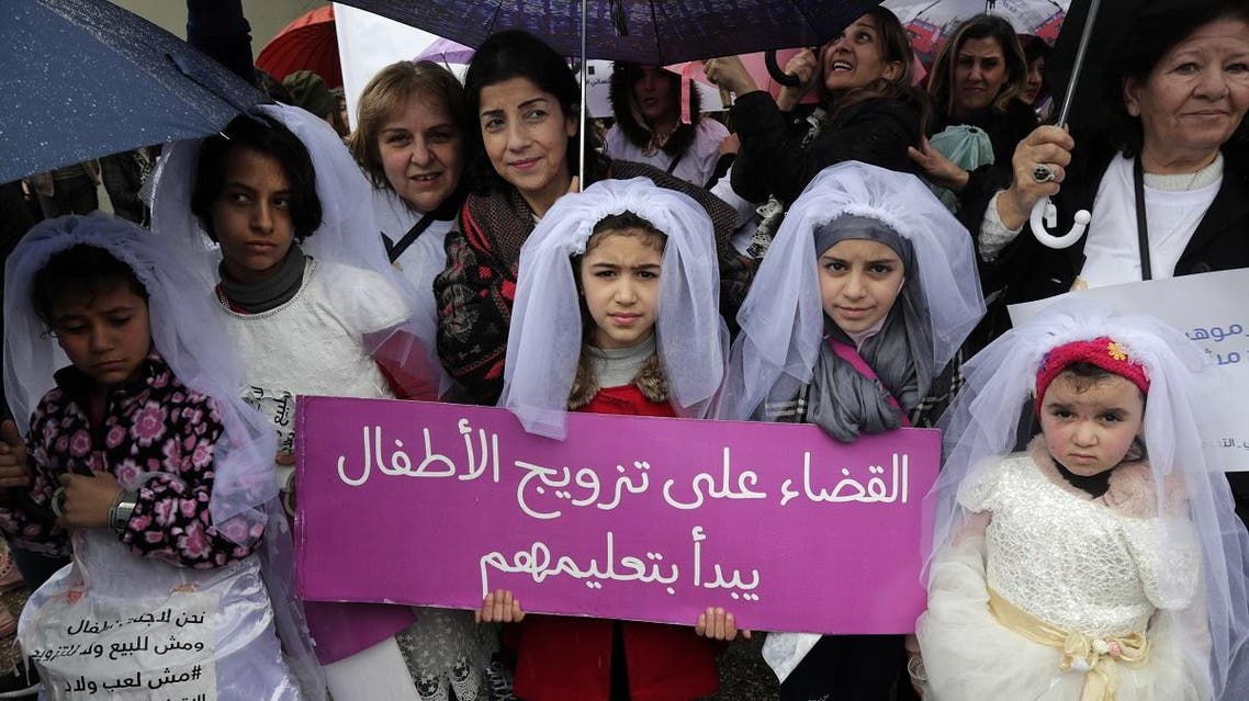 Young Lebanese girls disguised as brides hold a placard as they participate in a march against marriage before the age of 18, in the capital Beirut. (AFP)