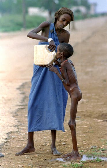 A starving Somali child is given water near a refugee camp in Baidoa, Somalia, on December 14, 1992. (Reuters/ Yannis Behrakis)