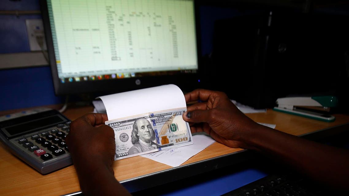 vAn employee shows US dollar banknotes at a foreign currency brokerage office in Khartoum on October 7, 2018. (AFP)