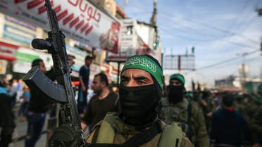 A member of Hamas' armed wing al-Qassam Brigades stands guard carrying a Kalashnikov assault rifle during the funeral of Ziad al-Howajri, one of the members of Hamas' security forces, in al-Nusairat refugee camp in the central Gaza Strip on March 22, 2018, after he was killed with a comrade while attempting to arrest a suspect in a bomb attack against the Palestinian prime minister during his visit to the enclave on March 13. 