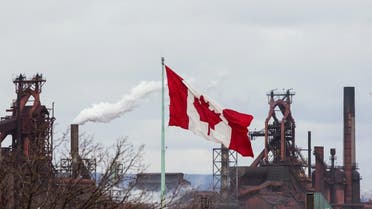 A Canadian flag flies above another industry site with ArcelorMittal Dofasco in the background in Hamilton, Ontario. (Reuters)