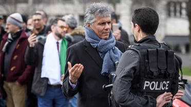Algerian businessman and political activist Rachid Nekkaz (L) argues with a police officer in front of the Geneva University Hospitals (HUG) buildings in Geneva on March 8, 2019. (AFP)