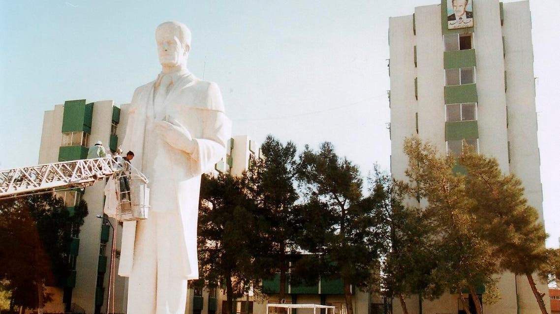 A file photo showing workers installing a statue of Syria’s former president Hafez al-Assad at the University of Damascus. (AP)