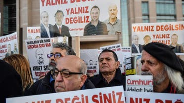 Protestors hold placards with images of jailed journalists in Istanbul on December 25, 2017. (AFP)